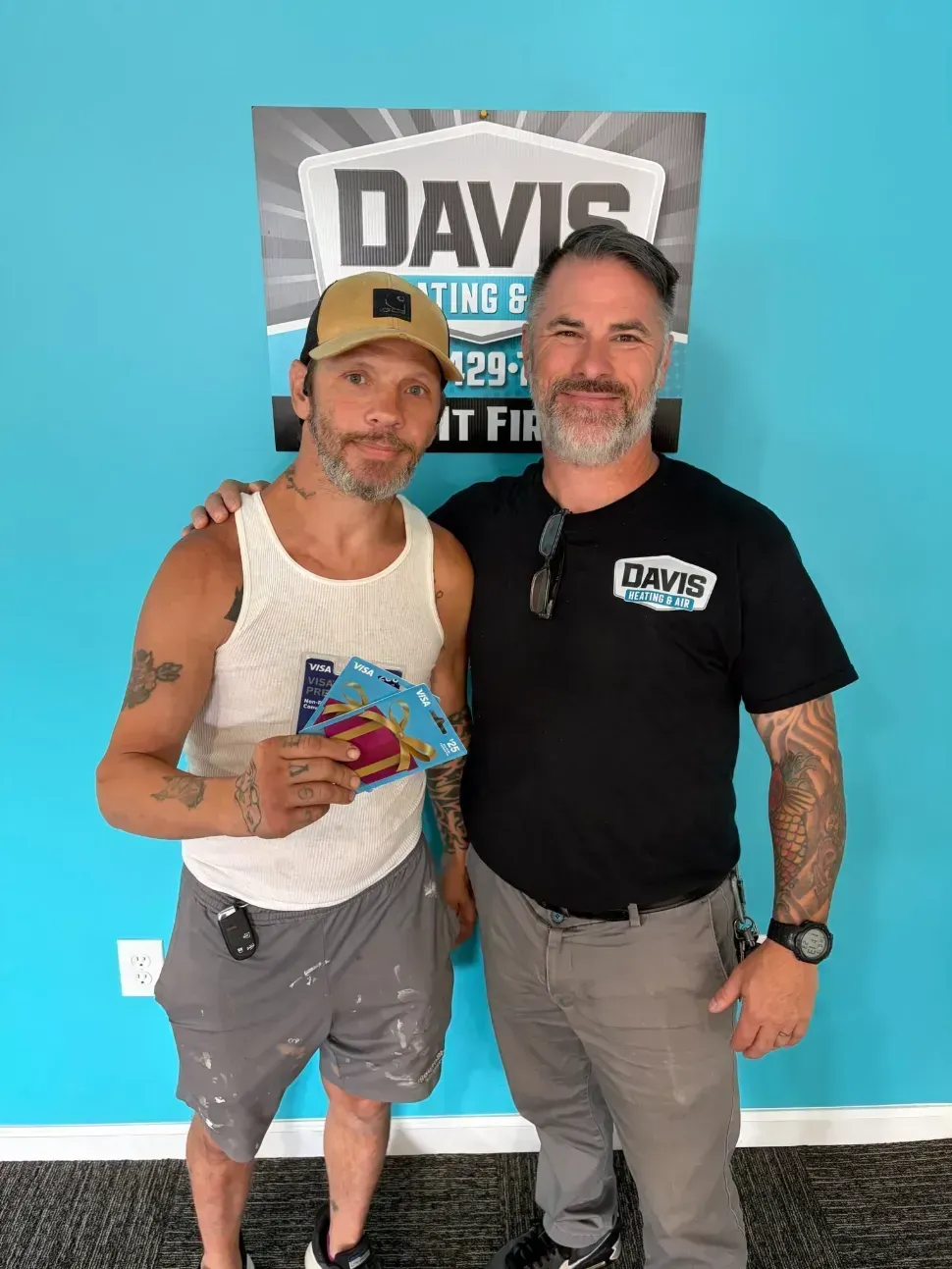 Davis tech with customer in front of sign