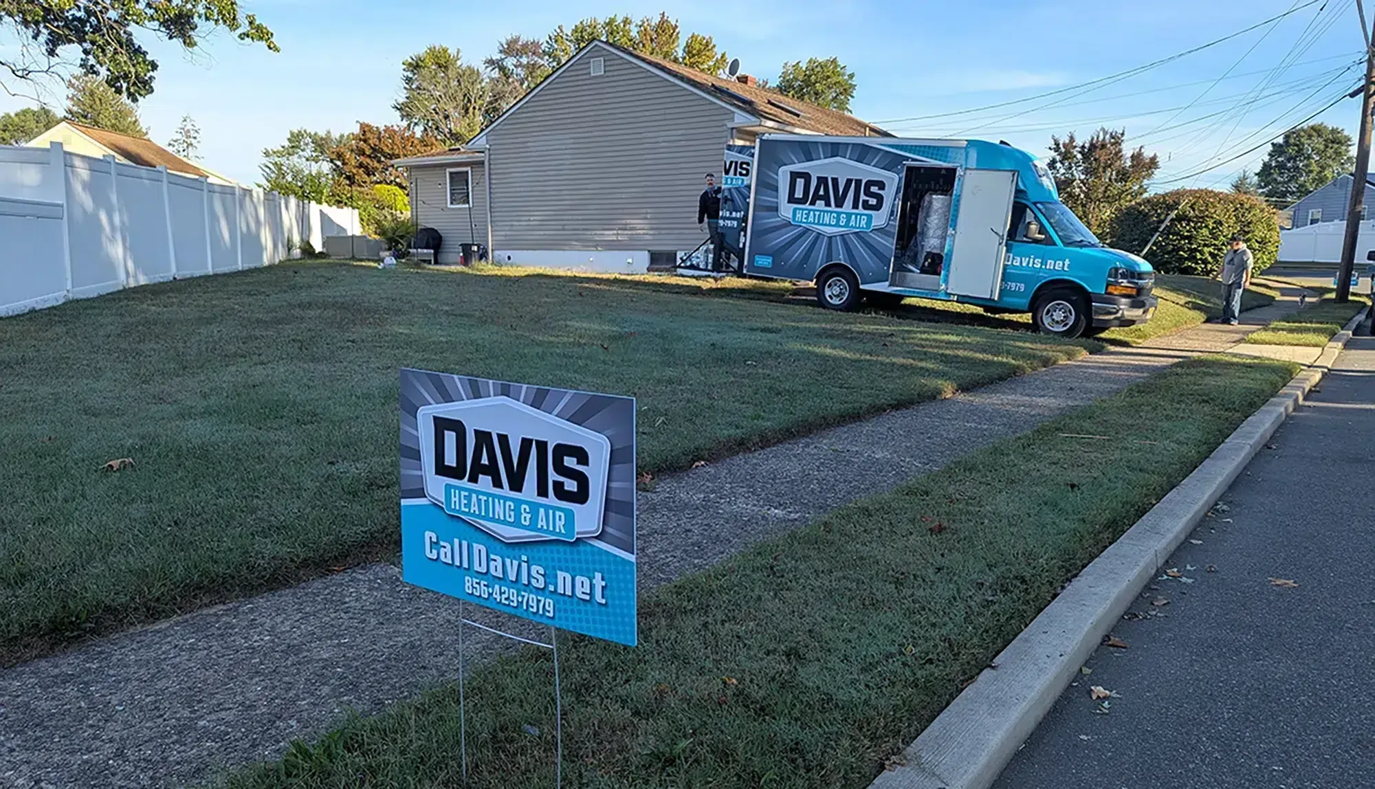 Davis Heating and Air service van parked at a Cherry Hill residence with yard sign