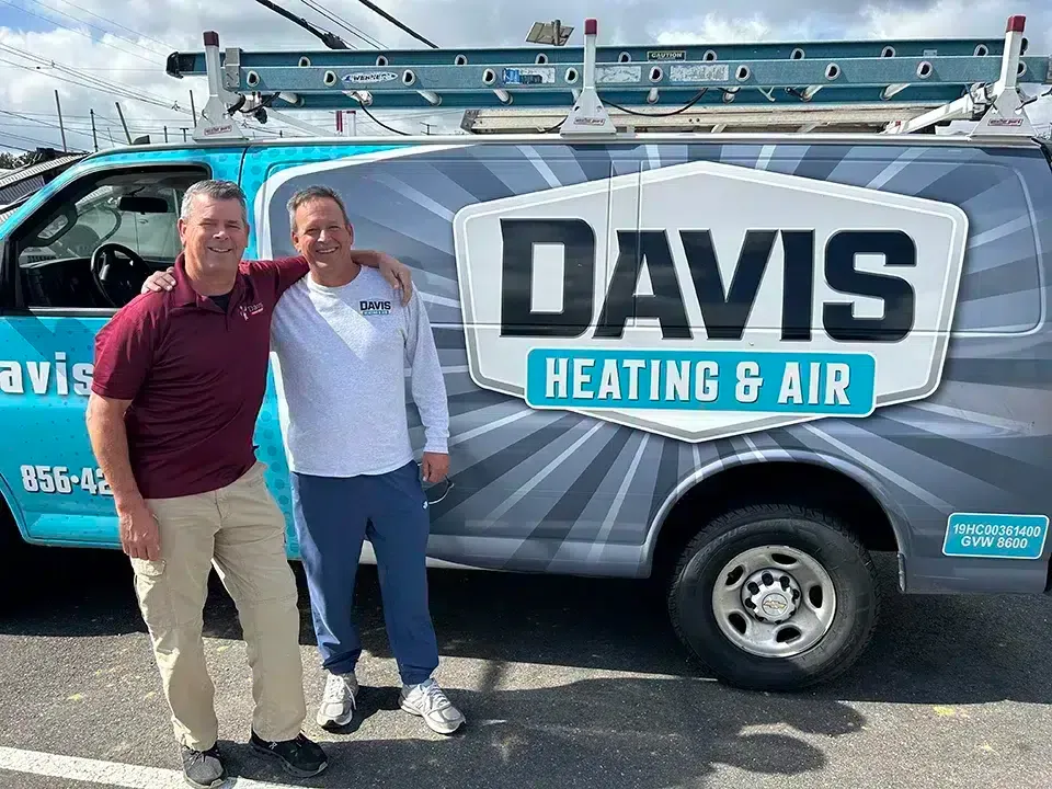 Davis Heating and Air team members standing by branded service van in Cherry Hill