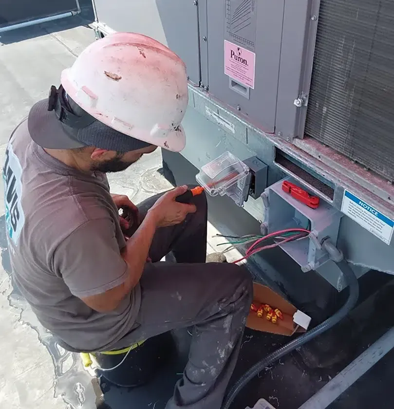 Davis Heating and Air technician performing rooftop HVAC electrical work in Cherry Hill