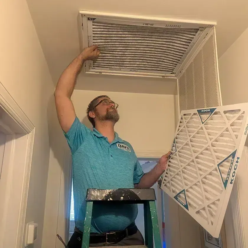 Davis Heating and Air technician replacing an air filter inside a Cherry Hill home