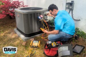 a Davis Heating and Air technician checking a newly installed heat pump outside a home in Cherry Hill, NJ