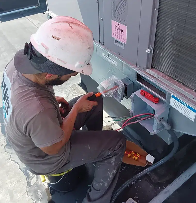 Davis Heating and Air technician performing rooftop HVAC electrical work in Cherry Hill