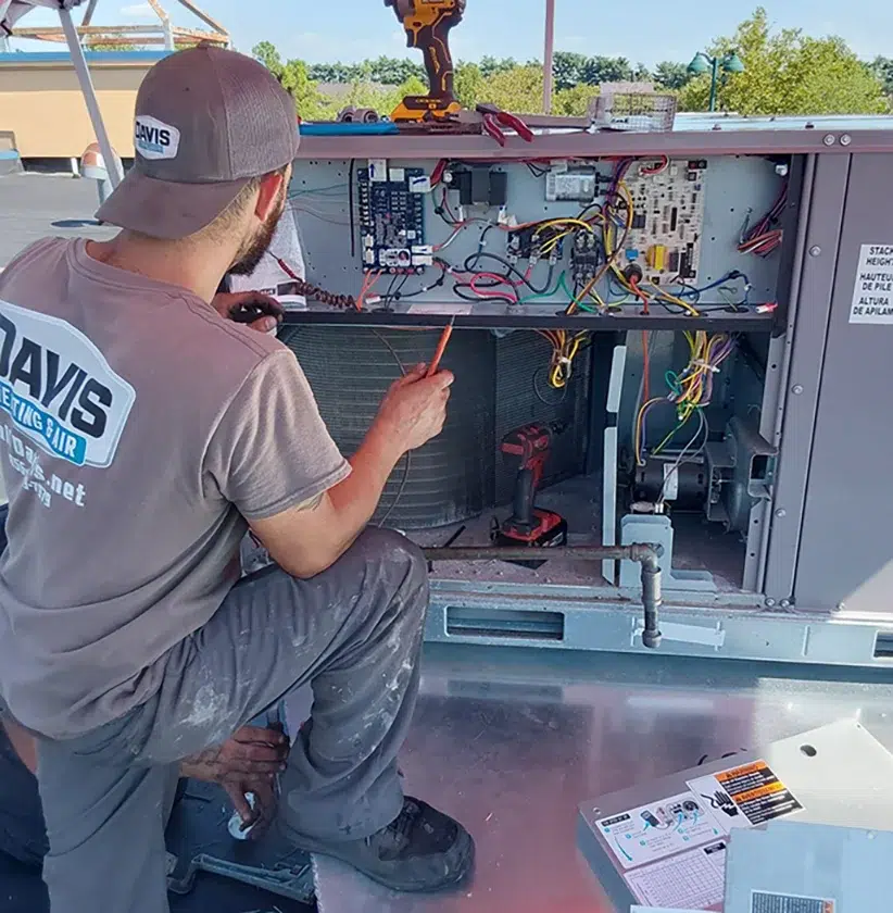 Technician repairing commercial HVAC system wiring for Davis Heating and Air in Cherry Hill